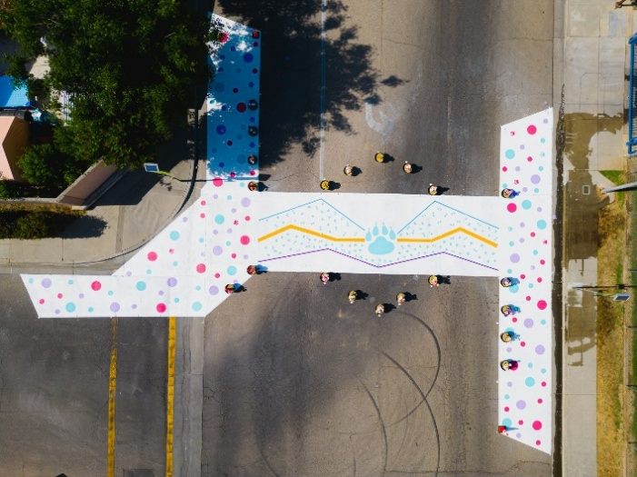 Aerial view of a finished thematic crosswalk with a school bear-paw design and bulb-outs