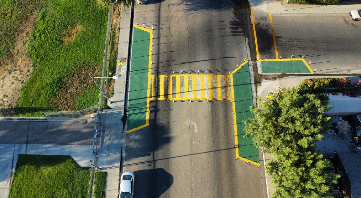 Aerial view of a green and yellow high-visibility crosswalk with bulb-outs