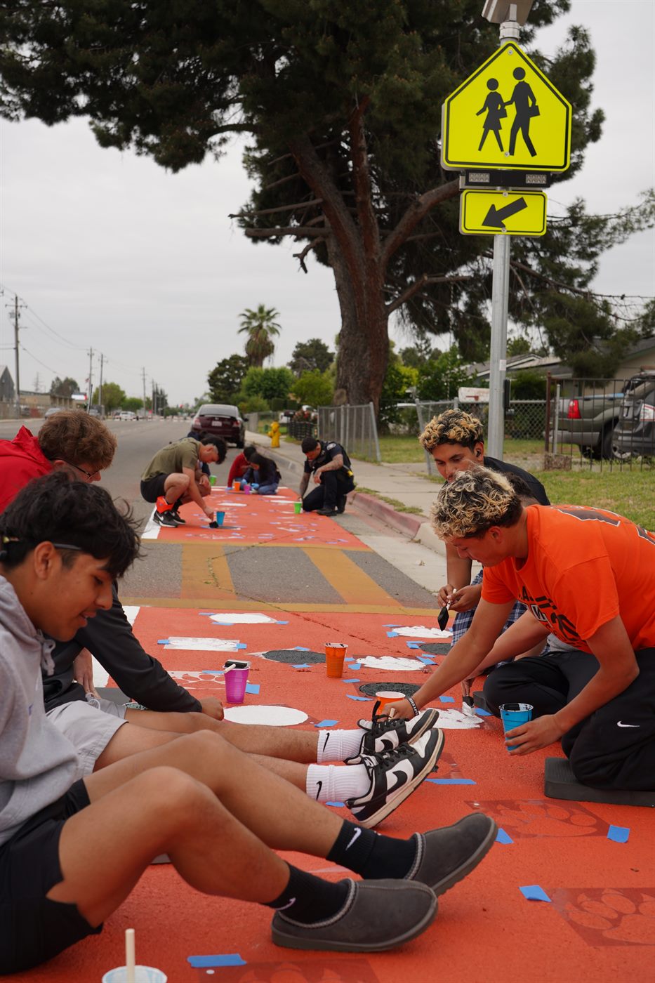 High school students painting bulb-outs on the street during a community event